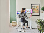 woman using ergonomic desk stool at work
