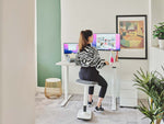 woman using ergonomic stool at office desk