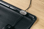magnetic cable holder, on a black desk mat
