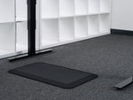 black standing desk floor mat on the floor