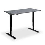 a simple, rectangular standing desk with a concrete effect top surface and black metal legs.