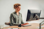Woman working, with PRF Ergonomic Vertical Wireless Mouse on desk