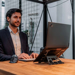 Side view of man using Aluminium universal laptop stand.