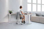 woman sat on a chair working on her laptop on a adjustable corner desk