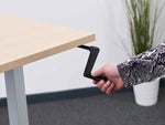 manual standing desk handle being turned 